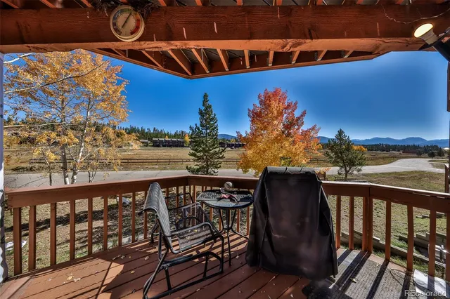a view of a balcony with wooden floor and outdoor seating