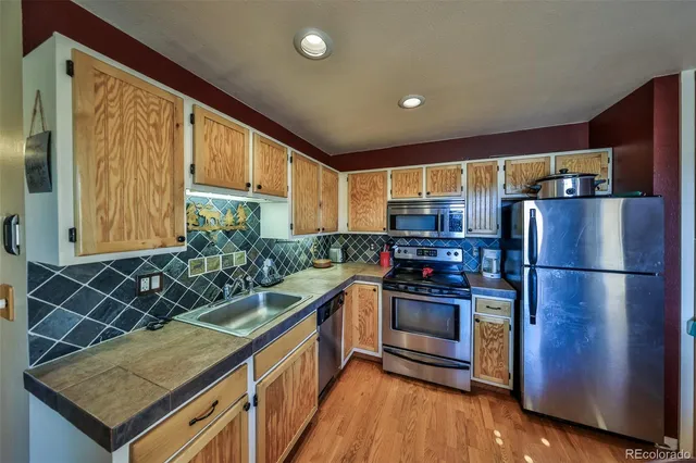 a kitchen with stainless steel appliances granite countertop a stove a sink and a refrigerator