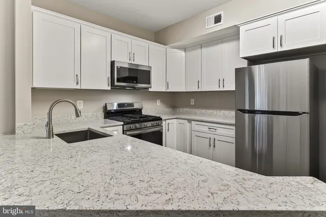 a view of a big room with wooden floor and windows