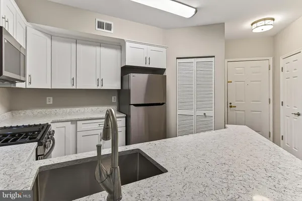 a kitchen with stainless steel appliances granite countertop a refrigerator sink and cabinets