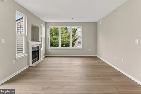 a view of a livingroom with a fireplace wooden floor and window