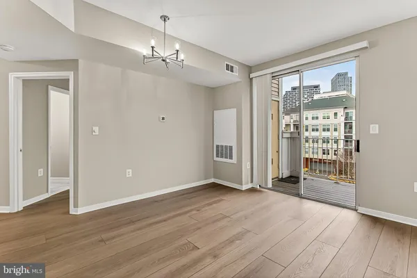 a view of a big room with wooden floor and windows
