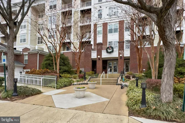 a kitchen with stainless steel appliances a stove top oven a sink dishwasher and a refrigerator with wooden floor