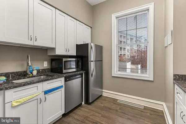 a kitchen with stainless steel appliances granite countertop a stove a sink and a refrigerator