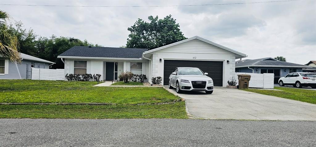 a view of a house with a small yard and a car parked in front of house