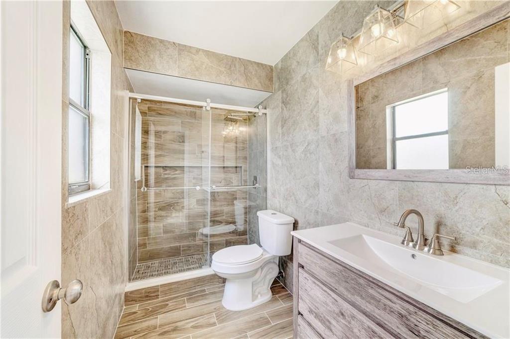 612 Estrada Lane Kissimmee, FL 34758 - Photo 5 of 8 a bathroom with a toilet sink a shower and a window