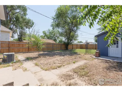 a backyard of a house with table and chairs