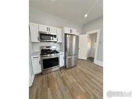 a kitchen with a refrigerator and a stove top oven