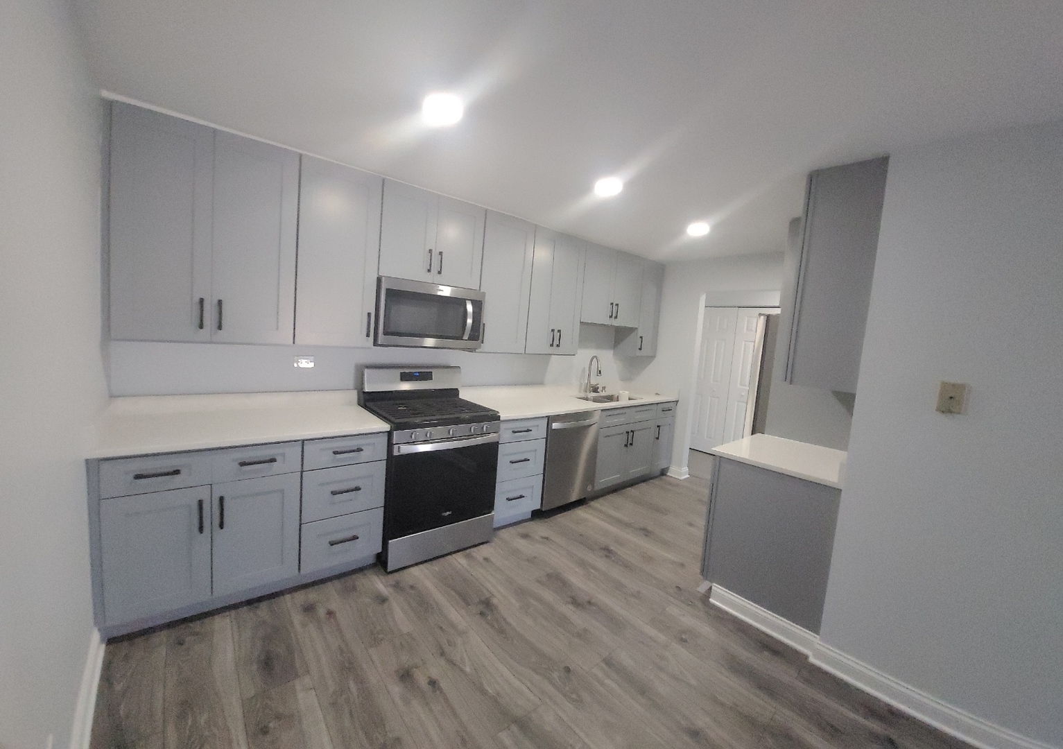 239 North Mill Road, Unit 310 Addison, IL 60101 - Photo 3 of 23 a kitchen with stainless steel appliances granite countertop a sink cabinets and wooden floor
