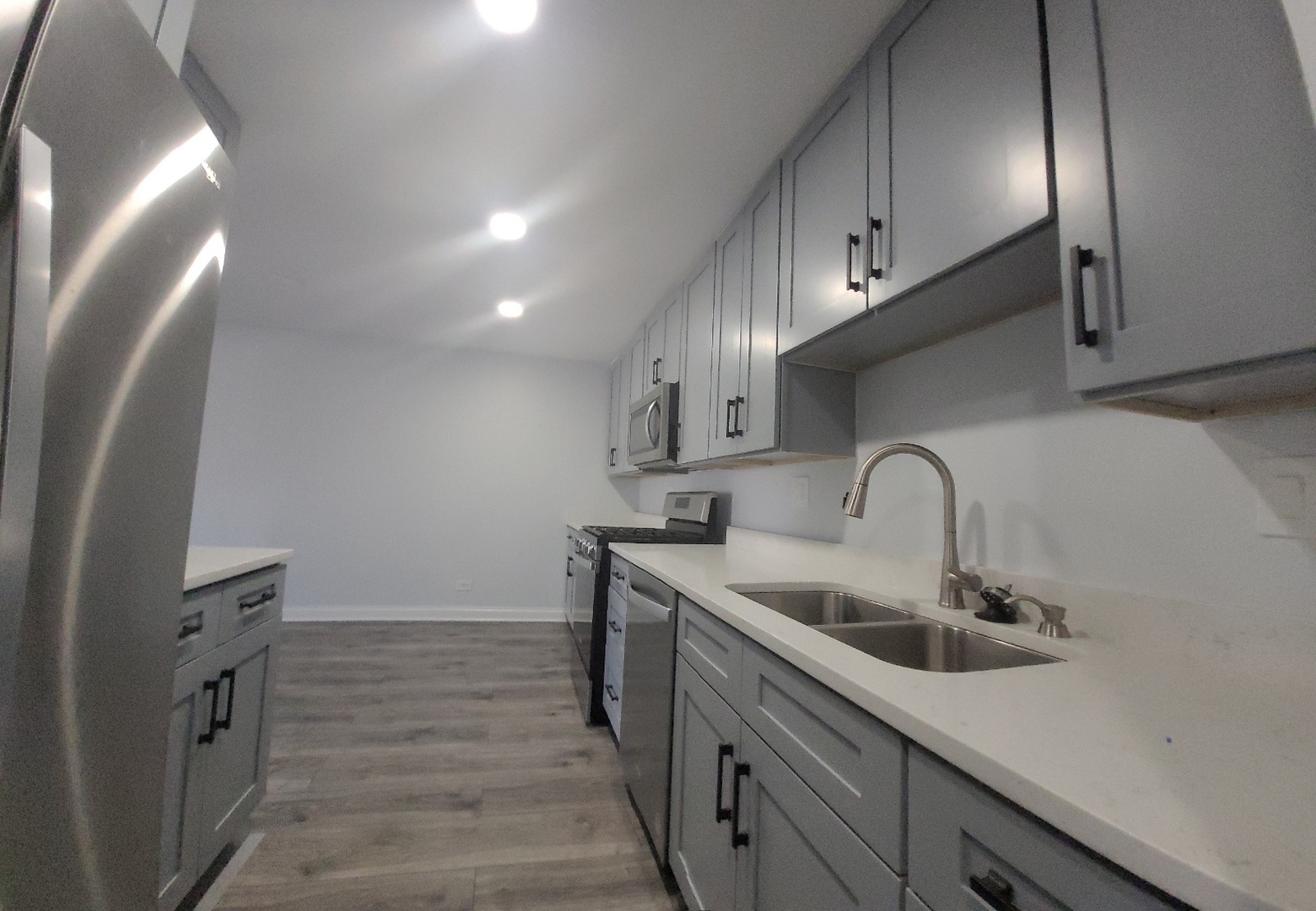 239 North Mill Road, Unit 310 Addison, IL 60101 - Photo 6 of 23 a kitchen with stainless steel appliances a sink stove and cabinets