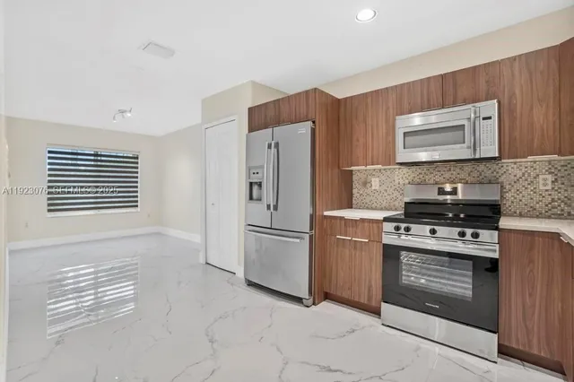 a kitchen with stainless steel appliances granite countertop a stove a refrigerator and a refrigerator