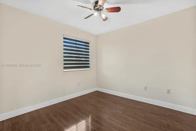 a view of a room with a window and a ceiling fan