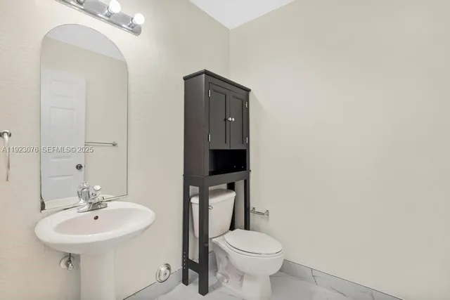 a bathroom with a toilet sink and mirror