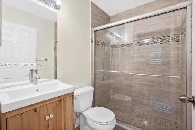 a bathroom with a sink a toilet and shower