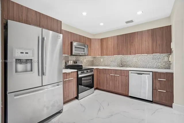 a kitchen with granite countertop cabinets and stainless steel appliances
