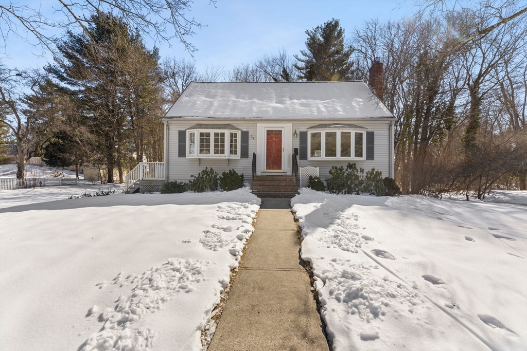 a front view of a house with a yard covered in snow