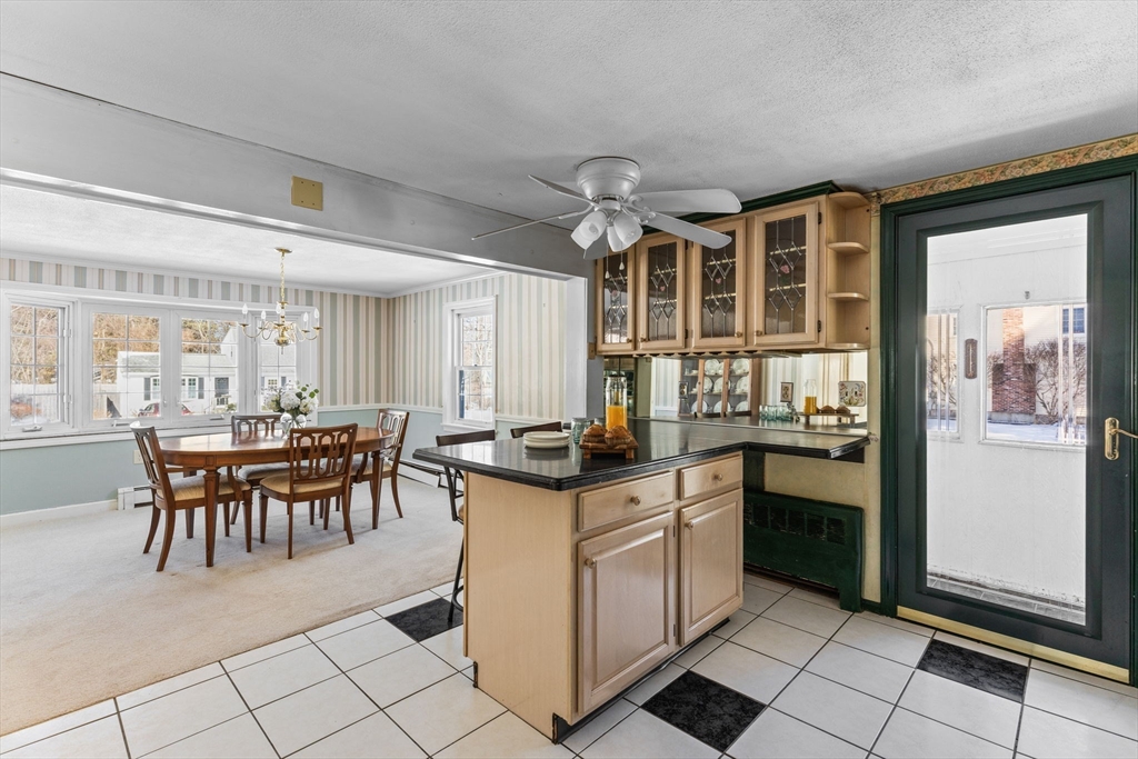 39 MacDonald Circle Walpole, MA 02081 - Photo 17 of 38 a kitchen with stainless steel appliances granite countertop a stove top oven a sink a dining table and chairs