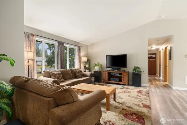 a living room with furniture a flat screen tv and a large window