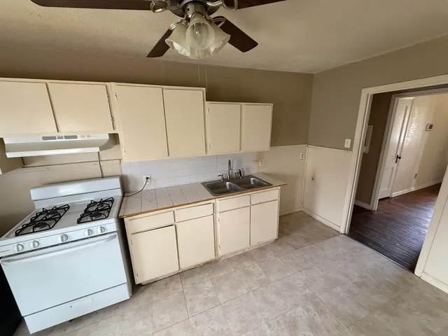 a kitchen with a stove and white cabinets