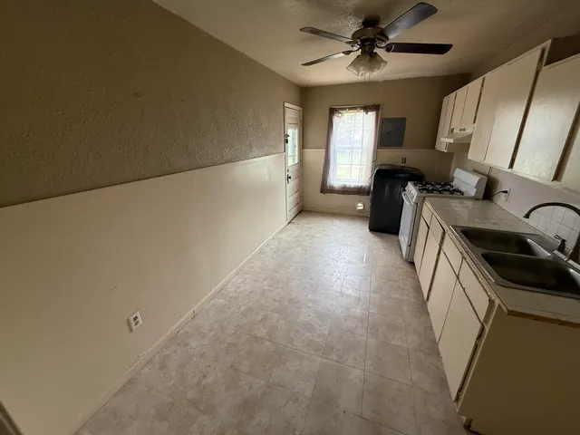a view of a kitchen with a sink cabinets and a ceiling fan