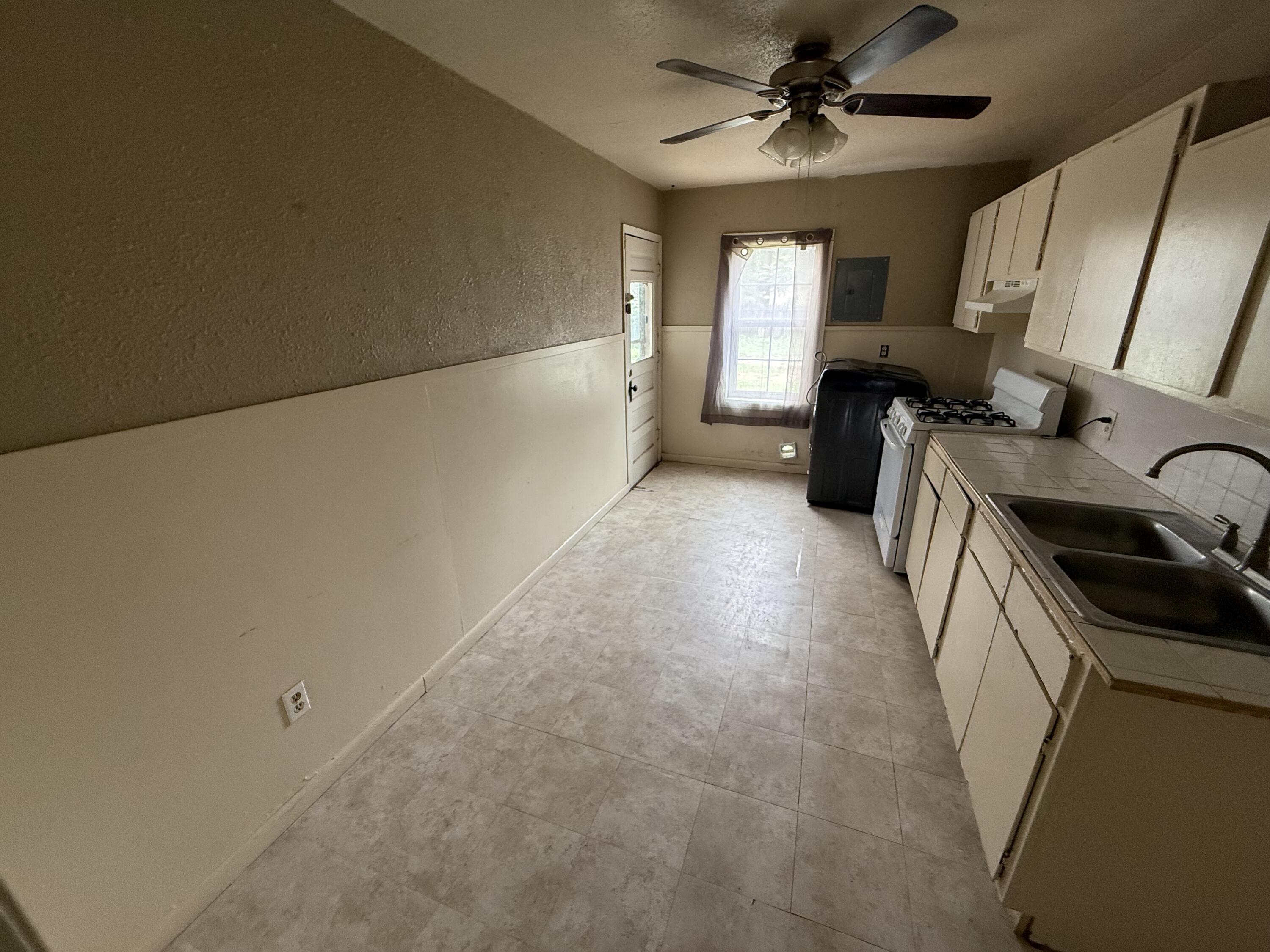 2416 31st Street Lubbock, TX 79411 - Photo 4 of 6 a view of a kitchen with a sink cabinets and a ceiling fan