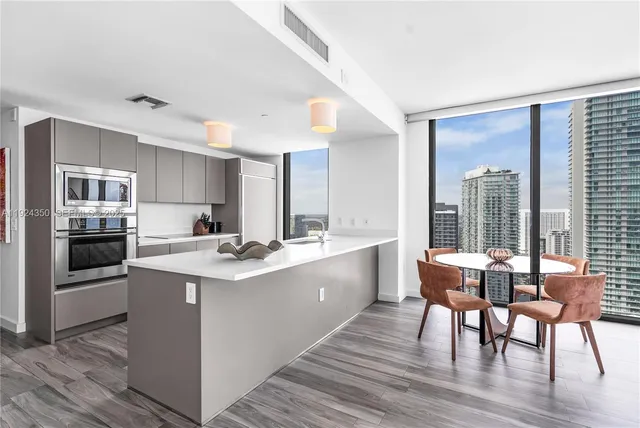 a kitchen with a sink and chairs
