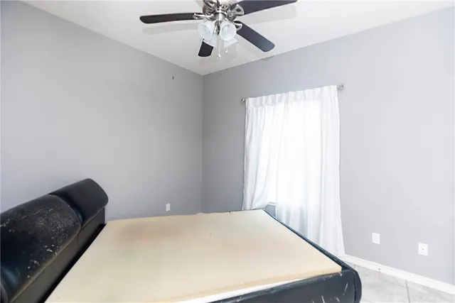 a bedroom with a bed and a ceiling fan