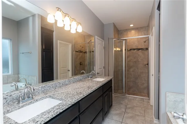 a bathroom with a granite countertop tub sink and mirror