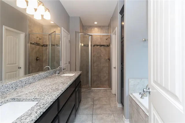 a bathroom with a granite countertop sink a toilet and shower