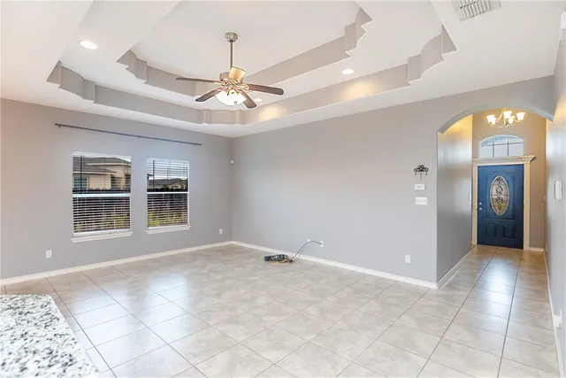 a view of a livingroom with a chandelier fan and windows
