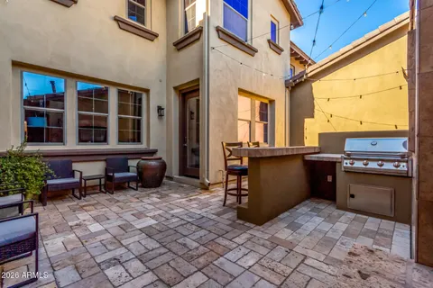 a view of a house with potted plants and a table and chairs