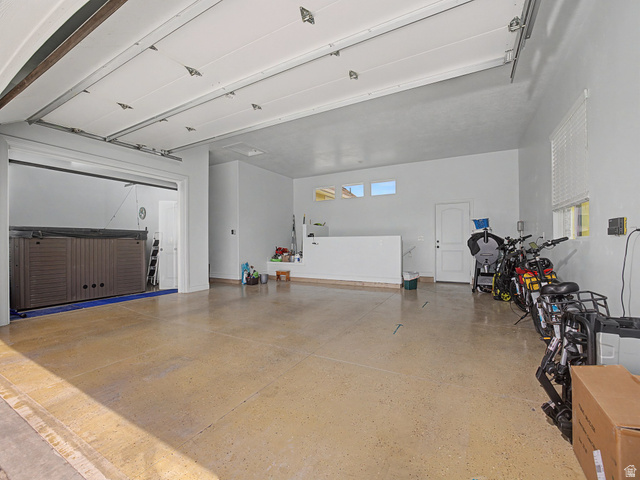 968 South Cyn Road Santaquin, UT 84655 - Photo 25 of 36 Spacious garage featuring a durable concrete floor, white walls, multiple windows for natural light, and an overhead garage door mechanism