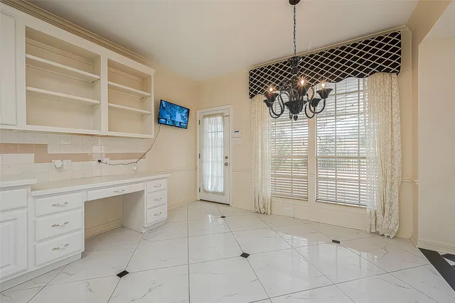 a large white kitchen with cabinets