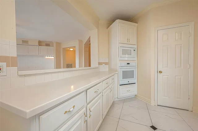 a view of an empty room with a cabinet and a window