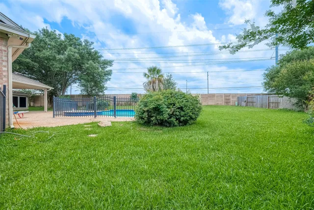 a view of a brick house with a big yard and large trees