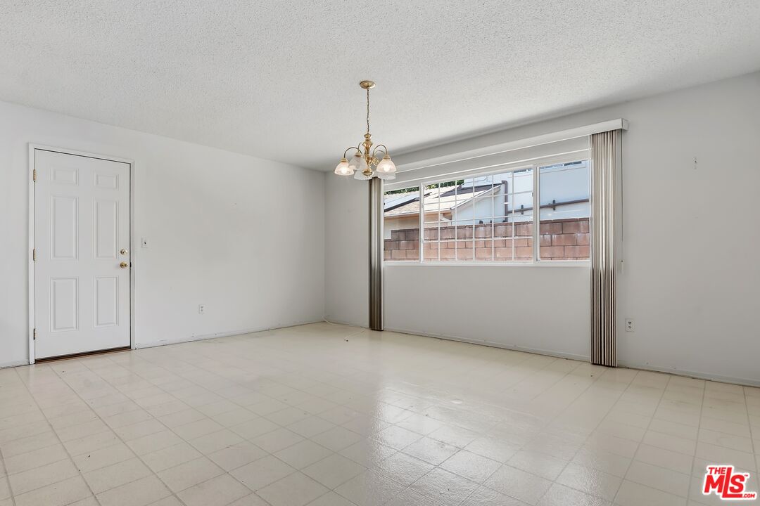 19131 Tulsa Street Porter Ranch, CA 91326 - Photo 10 of 43 an empty room with chandelier fan and windows