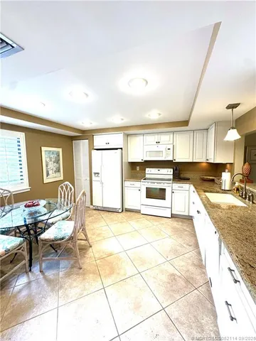 a large white kitchen with a stove a sink and a refrigerator