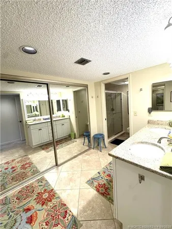 a spacious bathroom with a granite countertop sink and a mirror