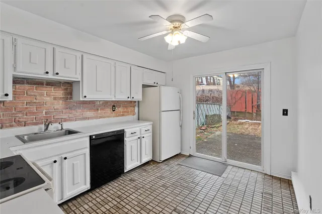 a kitchen with stainless steel appliances granite countertop a refrigerator a sink a stove and white cabinets
