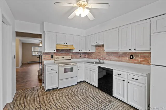 a kitchen with granite countertop a stove a sink and a refrigerator