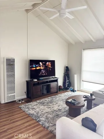 a living room with furniture a flat screen tv and a window