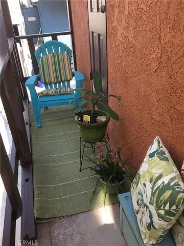 a living room with couches and kitchen view with wooden floor