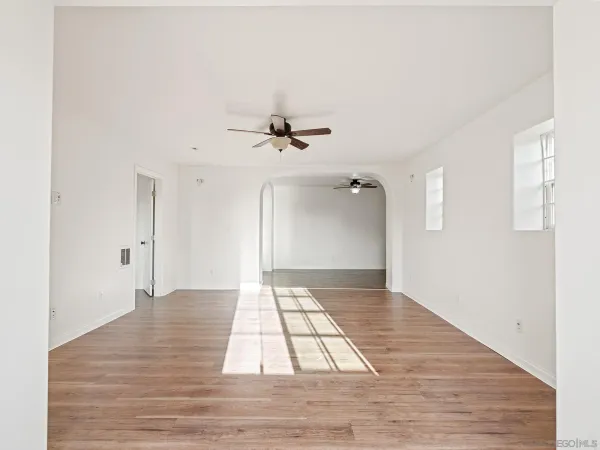 a view of a room with a ceiling fan and wooden floor