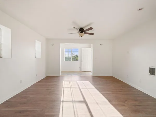 an empty room with fan and windows