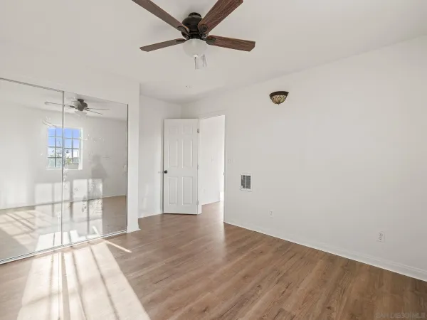 a view of a livingroom with wooden floor and a ceiling fan