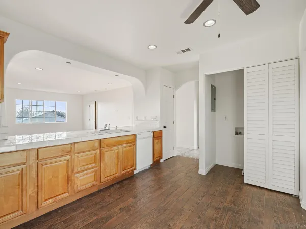 a large white kitchen with a sink stainless steel appliances and cabinets
