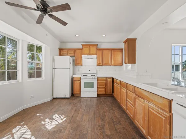 a kitchen with a refrigerator a sink and dishwasher with wooden floor