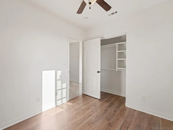 an empty room with closet and windows