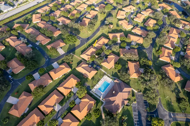 an aerial view of a residential apartment building with a yard and plants