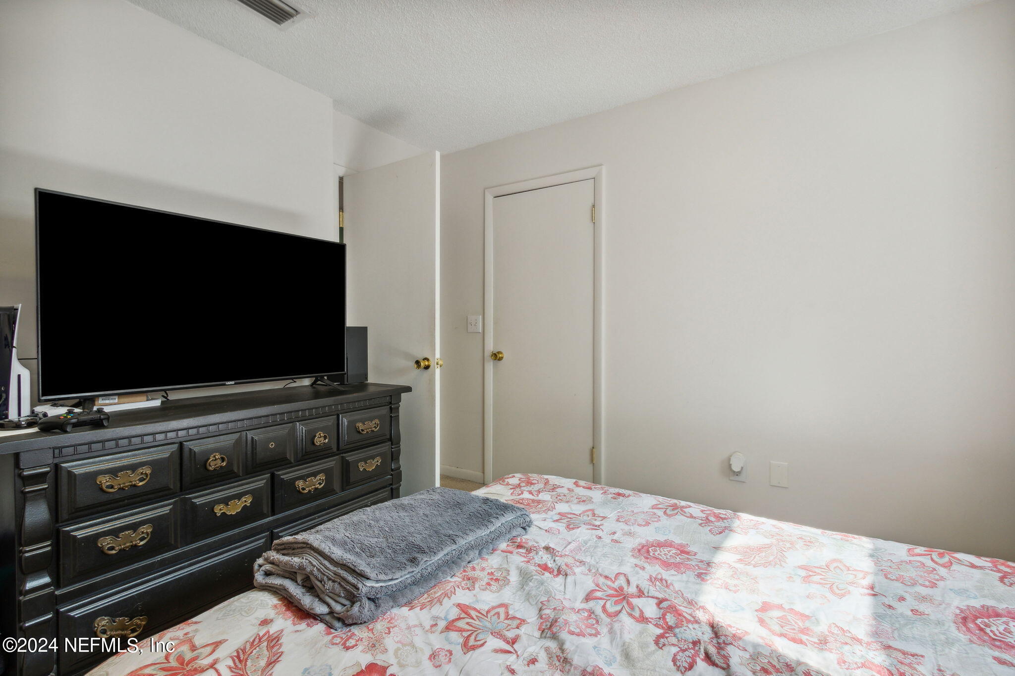 97125 Pirates Point Road Yulee, FL 32097 - Photo 45 of 90 a bedroom with a bed and a flat screen tv